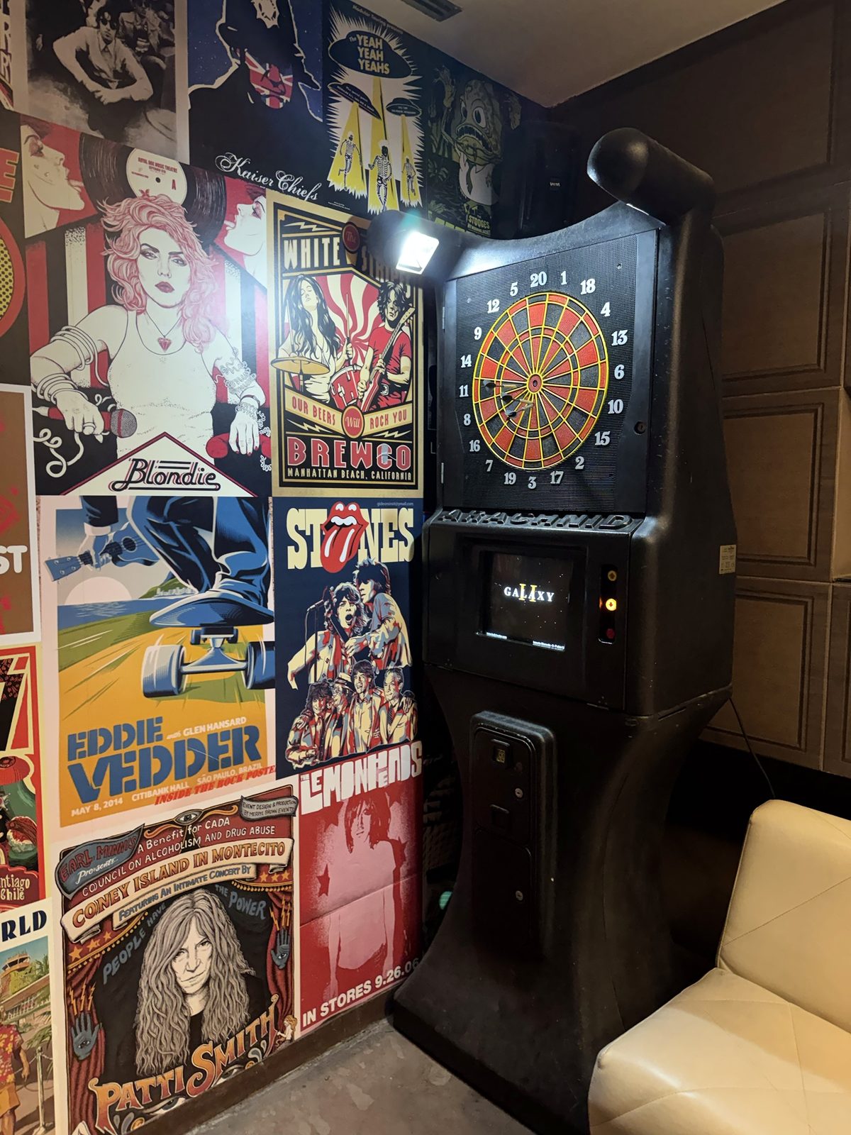 Máquina de dardos electrónica junto a la pared de carteles