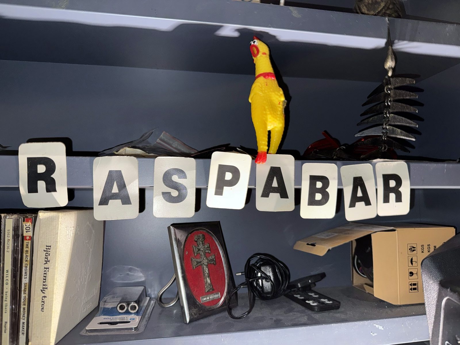 Letras de Raspabar sobre la estantería con un pollo de goma amarillo