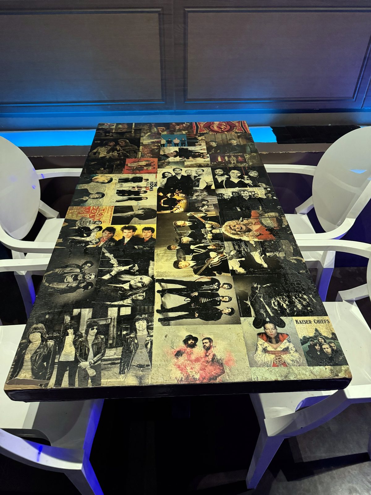 Mesa forrada con fotos de grupos como Ramones, Kaiser Chiefs o The Kooks